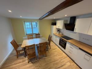 a kitchen with a wooden table and chairs in it at Ferienhaus am Johannesberg in Heuthen