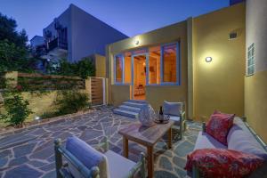 a patio with couches and a table in front of a house at Garden Residence in Ermoupoli