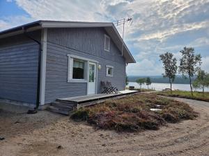 a small blue house with a bench on a porch at Villa Sevettijärvi in Sevettijärvi +27 photos