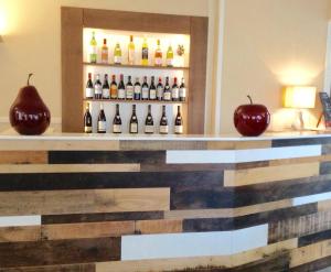 une présentation de bouteilles de vin et de pommes sur un comptoir dans l'établissement Hôtel Restaurant de la Place, à Saint-Jean-dʼAngély