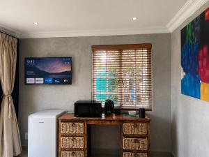 a room with a table with a microwave and a window at Limonite Guesthouse in Pretoria