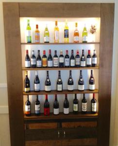 une armoire d'affichage remplie de nombreuses bouteilles d'alcool dans l'établissement Hôtel Restaurant de la Place, à Saint-Jean-dʼAngély