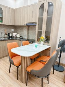 a kitchen with a table and orange chairs at A2 House Cát Bà in Cat Ba +12 photos