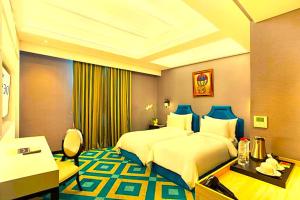 a hotel room with a large bed and a desk at Hotel Madhurika Palace in Dhanbād