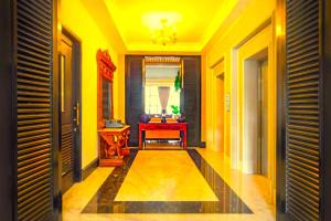a hallway with yellow walls and a red table at Hotel Madhurika Palace in Dhanbād