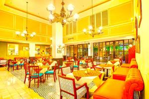 a restaurant with tables and chairs in a room at Hotel Madhurika Palace in Dhanbād