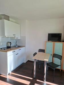a kitchen with a table and two chairs and a counter at Zakątek Turysty in Gdańsk