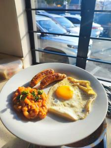 a plate of breakfast food with eggs sausage and beans at 33onBazley Hotel in Durban