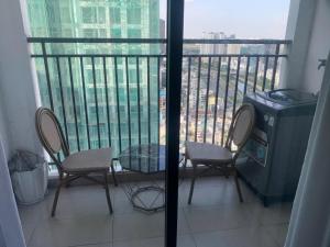 a balcony with two chairs and a table and a trash can at ARVO Cam Ranh - Infinity swimming pool in Cam Ranh International Airport