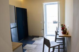 a kitchen with a refrigerator and a table with chairs at Lidi & Miti in Bacoli +15 photos