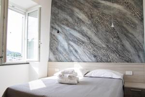 a bedroom with a bed with a towel on it at Lidi & Miti in Bacoli