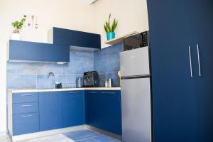 a kitchen with blue cabinets and a white refrigerator at Lidi & Miti in Bacoli