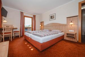 a bedroom with a large bed and a table at Landhaus Rieding in Mühlbach am Hochkönig