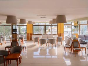 a waiting room at a hospital with chairs and tables at Aparthotel Ona Aucanada in Port d'Alcudia
