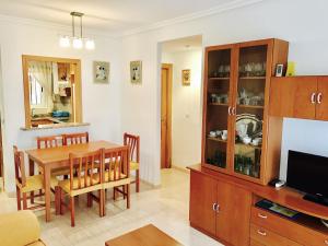 comedor y sala de estar con mesa y TV en Apartamento Caribe Playa, en Oropesa del Mar