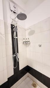 a bathroom with a shower with a shower head at Secret Garden Beach Hotel in Trincomalee