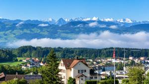 a town in the mountains with clouds in the valleys at Swiss Horizon - Mythenblick - Modern 100m2 mit Alpenblick und Terrassen in Hinwil