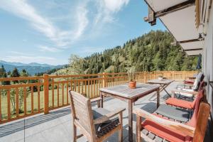 a patio with tables and chairs on a balcony with mountains at Landhaus Rieding in Mühlbach am Hochkönig