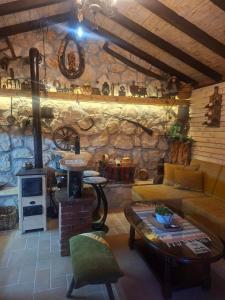 a living room with a couch and a stone wall at Etno House Šćepanov Hlad in Virpazar