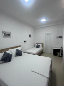 a bedroom with two beds and a tv in it at Guest House Mario in Berat