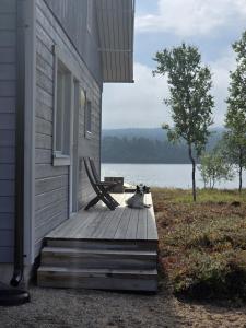 a cat laying on a wooden porch with a bench at Villa Sevettijärvi in Sevettijärvi