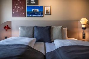 a bedroom with two beds and a couch at Scandic Kødbyen in Copenhagen