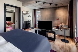 a bedroom with a bed and a tv and a couch at Scandic Kødbyen in Copenhagen