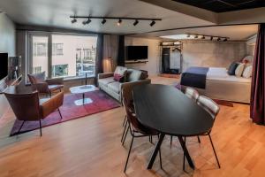 a living room with a bed and a table and chairs at Scandic Kødbyen in Copenhagen +54 photos