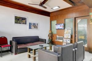 a living room with a couch and a table and chairs at Super Collection O MG Road in Cochin