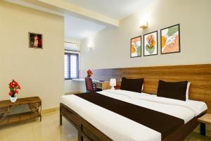 a bedroom with a large bed in a room at Super Collection O MG Road in Cochin +43 photos