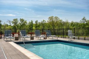 a swimming pool with chairs and a table at Hampton Inn By Hilton Lawrenceburg in Lawrenceburg