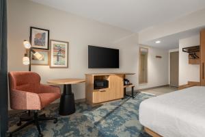 a hotel room with a bed and a desk and a television at Hampton Inn By Hilton Lawrenceburg in Lawrenceburg