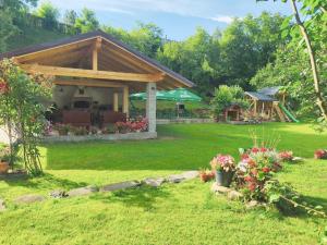 a pavilion in a garden with flowers in a yard at Casa Luca in Ceahlău