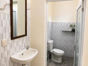 ein Badezimmer mit Toilette, Waschbecken und Spiegel in der Unterkunft Buana Asti Homestay Retreat Batukaru in Tabanan