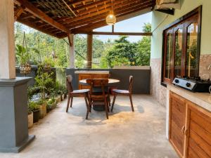 eine Terrasse mit Tisch und Stühlen in der Unterkunft Buana Asti Homestay Retreat Batukaru in Tabanan