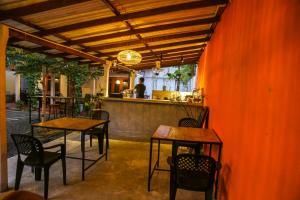 a restaurant with tables and chairs and a counter at One More Day Hostel, Weligama Beach in Weligama