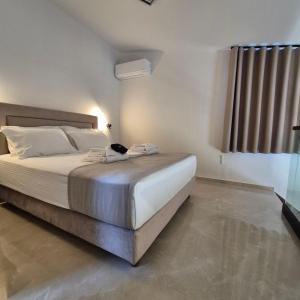 a bedroom with a large bed with white sheets at Sage Villas in Plataria +42 photos