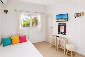 a bedroom with a bed with colorful pillows and a table at Beach House Cavo Kiotari in Gennadi