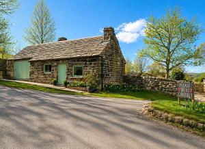 a stone house on the side of a road at The Old Smithy in Langsett