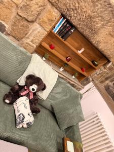 a teddy bear sitting on a couch in a room at The Old Smithy in Langsett