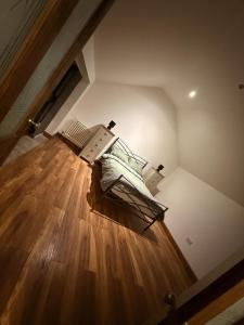 an attic room with a bed and wooden floors at The Old Smithy in Langsett