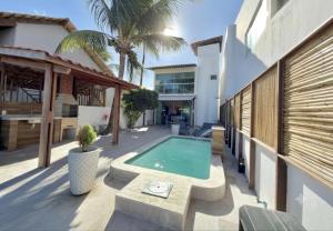 a backyard with a swimming pool and a house at Brisa de Barra Grande Beach House Pé na Areia in Maragogi