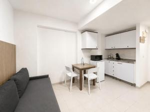 a living room with a couch and a table and a kitchen at Apartamentos El Faro By Mc in Benidorm