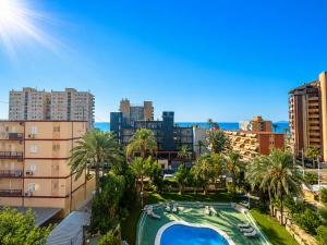 a view of a city with a swimming pool and palm trees at Apartamentos El Faro By Mc in Benidorm