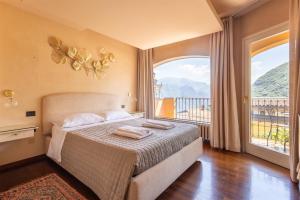 a bedroom with a bed and a large window at IseoLakeRental - Nido Belvedere in Fonteno