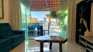 a living room with a coffee table and a glass wall at Brisa de Barra Grande Beach House Pé na Areia in Maragogi