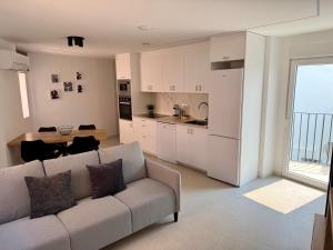 a living room with a couch and a kitchen at Apartamentos San Antonio - GrupoAMI in Ontinyent