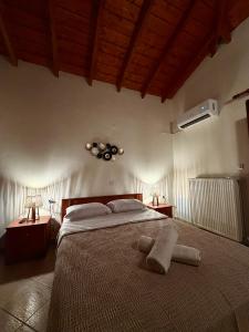 a bedroom with a large bed with two lamps and a fan at Blue Horizon Makri in Alexandroupoli