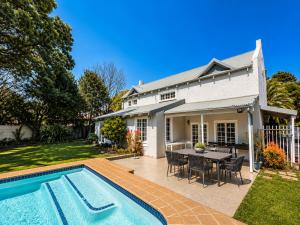 a house with a swimming pool and a table and chairs at Limonite Guesthouse in Pretoria