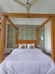 a large bed in a bedroom with a brick wall at The Sanmit Stay Kasauli by Splendid Retreat Hotels in Kasauli